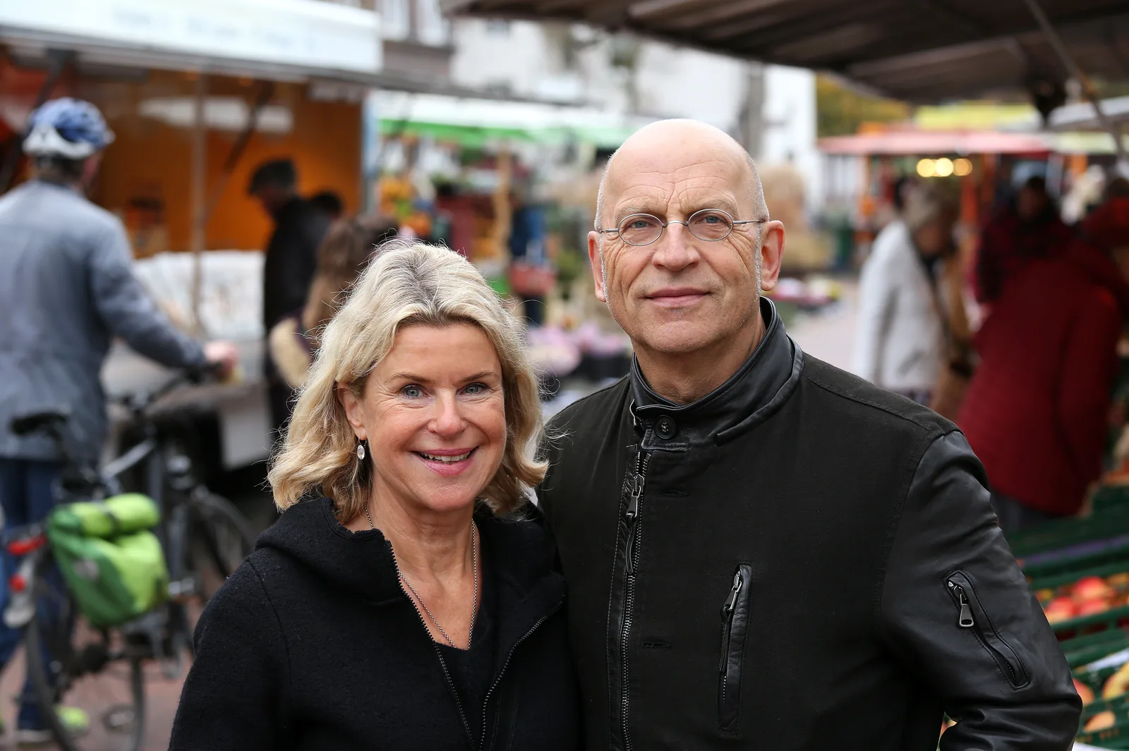 Zwei Ärzte der Markt-Sprechstunde lächeln auf dem Wochenmarkt in Hannover-List